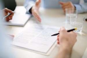 Cropped view of businessman signing contract at meeting